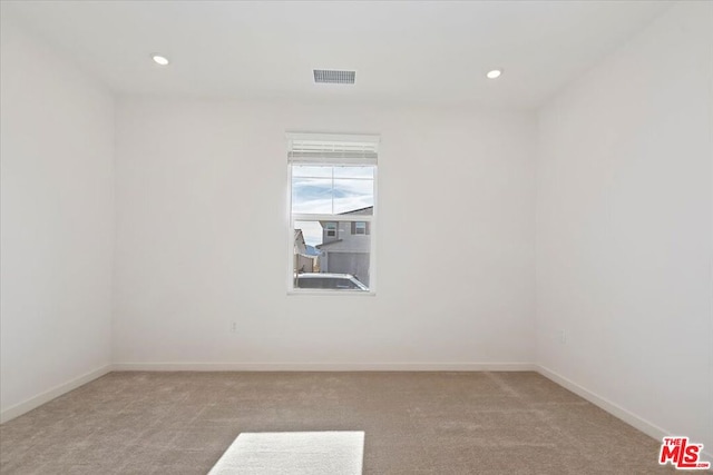 spare room featuring light colored carpet