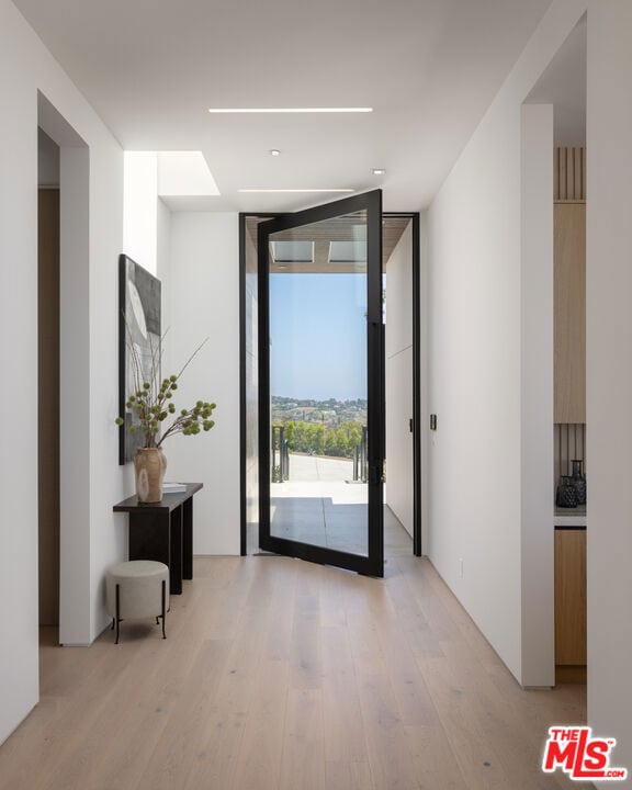 interior space featuring expansive windows and light hardwood / wood-style flooring