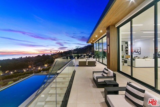 pool at dusk with an outdoor hangout area