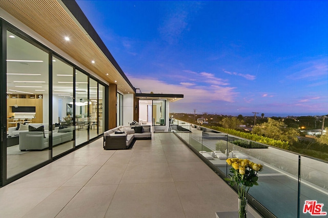 balcony at dusk featuring an outdoor hangout area