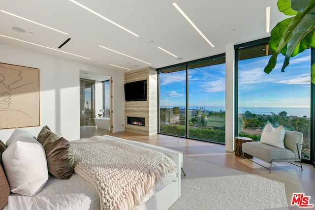 bedroom with a wall of windows and a large fireplace