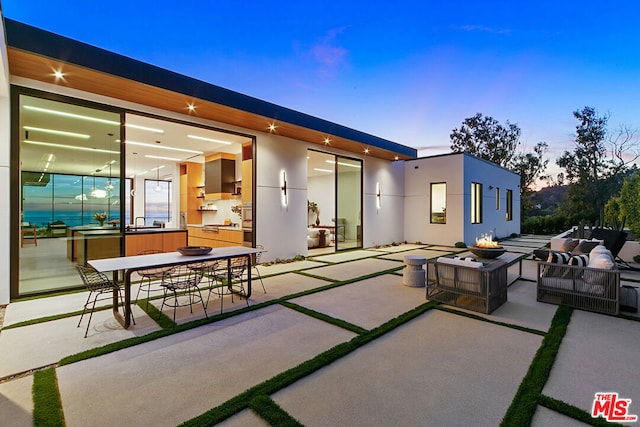 patio terrace at dusk with sink and a fire pit