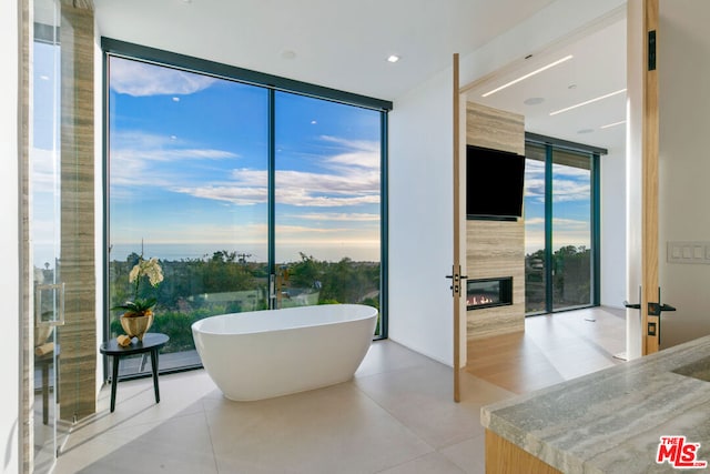 bathroom with tile patterned floors, expansive windows, and a bathing tub