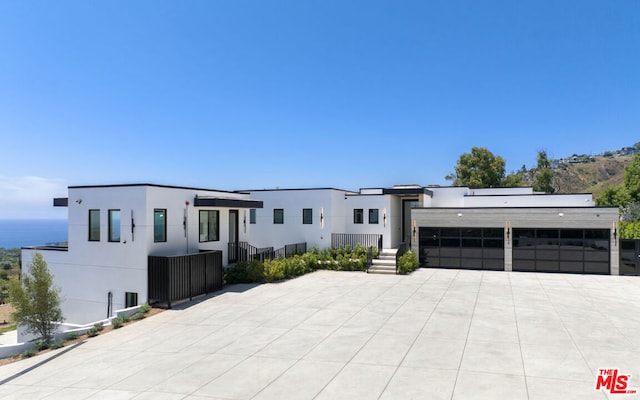 contemporary home featuring a garage and a water view