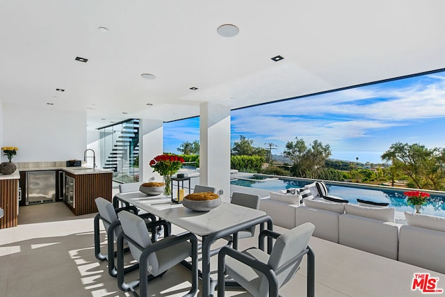 view of patio with outdoor lounge area, beverage cooler, and a wet bar