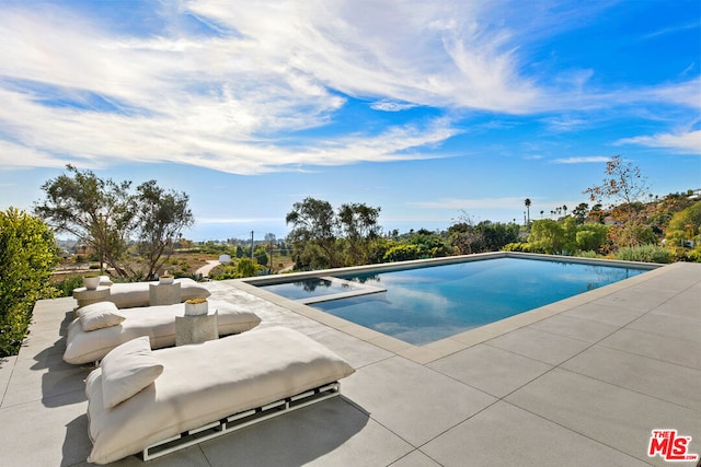 view of pool with a patio and an in ground hot tub