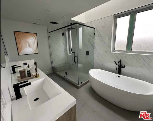 bathroom with vanity and shower with separate bathtub