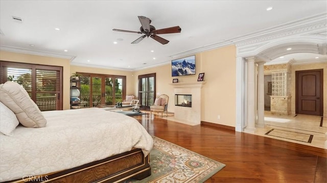 bedroom with hardwood / wood-style floors, crown molding, decorative columns, and ceiling fan