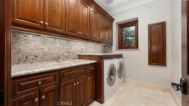 washroom featuring cabinets, ornamental molding, separate washer and dryer, and sink