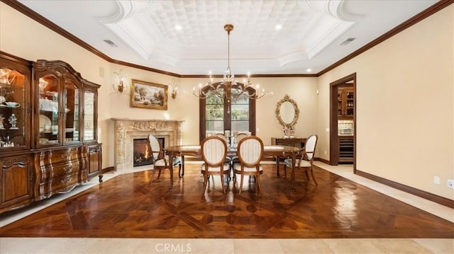 dining room featuring light parquet flooring, a premium fireplace, ornamental molding, a raised ceiling, and a chandelier