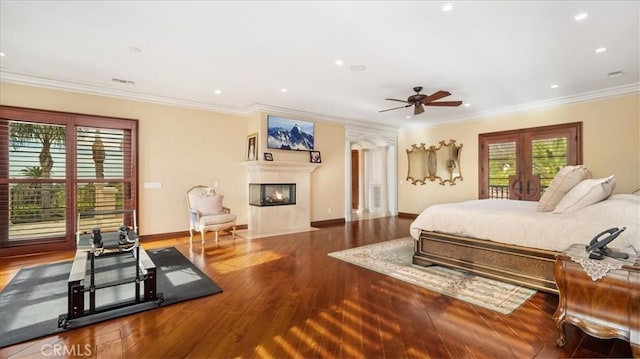 bedroom featuring multiple windows, crown molding, hardwood / wood-style floors, and ceiling fan