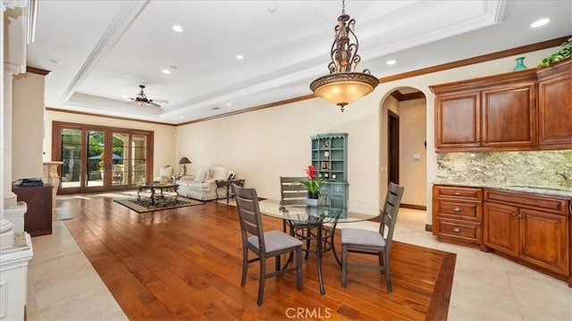 dining area with french doors, sink, light hardwood / wood-style flooring, a raised ceiling, and ceiling fan