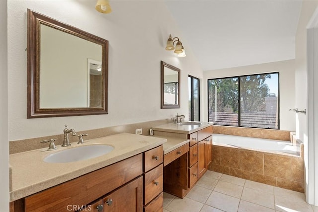 bathroom with tiled bath, vaulted ceiling, vanity, and tile patterned flooring