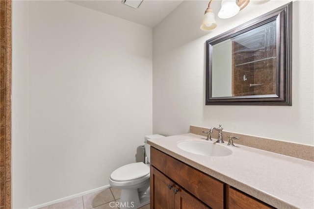 bathroom with toilet, vanity, and tile patterned flooring