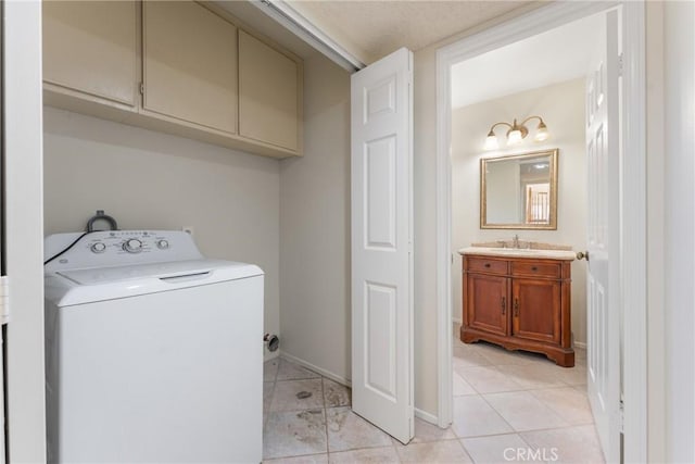 clothes washing area featuring washer / dryer, cabinets, light tile patterned floors, and sink