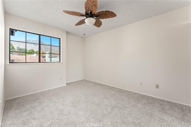 carpeted spare room with ceiling fan and a textured ceiling