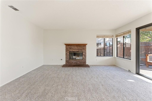 unfurnished living room featuring a brick fireplace and carpet floors