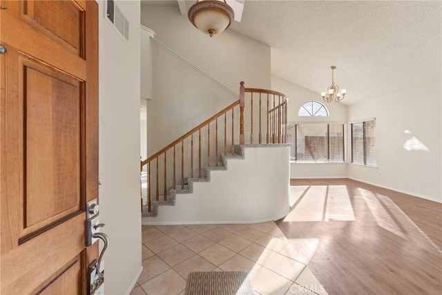 tiled foyer entrance featuring a notable chandelier