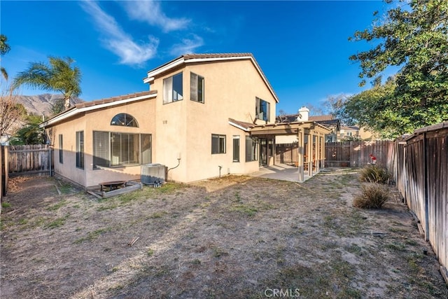 rear view of property featuring central AC and a patio