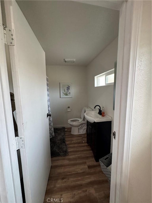 bathroom with toilet, wood-type flooring, and vanity