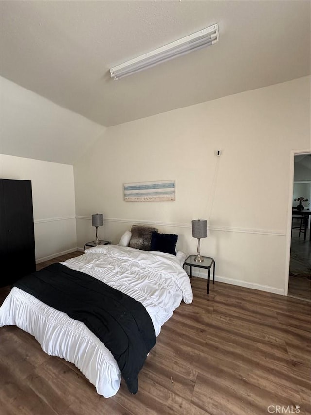 bedroom featuring lofted ceiling and dark hardwood / wood-style floors