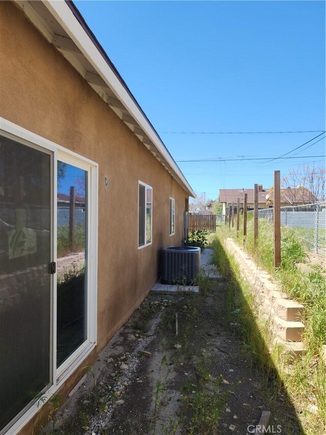 view of side of home with central air condition unit