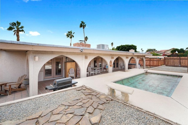 view of swimming pool featuring a patio and french doors