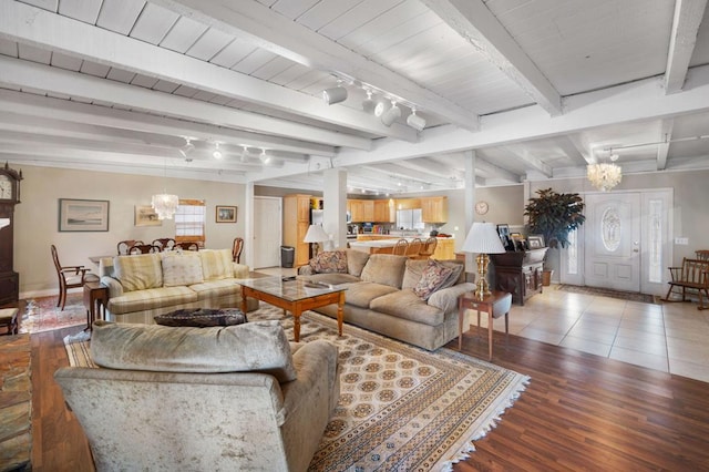 living room with hardwood / wood-style flooring, beam ceiling, and an inviting chandelier