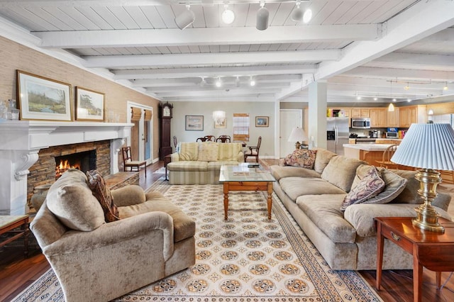 living room with track lighting, wood ceiling, beam ceiling, a fireplace, and light hardwood / wood-style floors