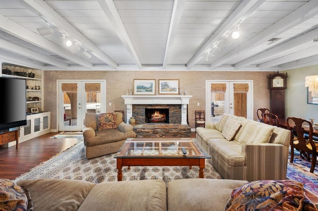 living room with a fireplace, french doors, beamed ceiling, and track lighting