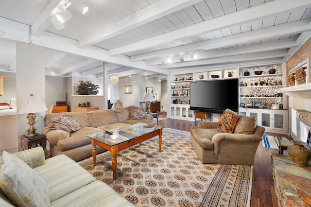 living room featuring beamed ceiling, built in shelves, and hardwood / wood-style flooring