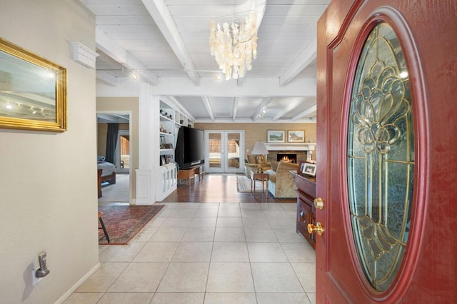 entrance foyer featuring beamed ceiling, light tile patterned floors, french doors, and a notable chandelier