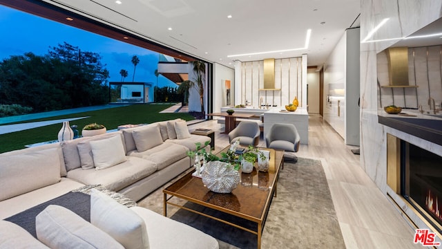 living room featuring light wood-type flooring and floor to ceiling windows