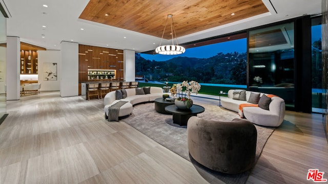 interior space featuring floor to ceiling windows, a raised ceiling, and wood ceiling