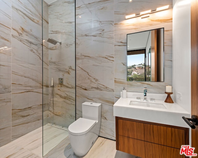 bathroom with toilet, vanity, and tiled shower