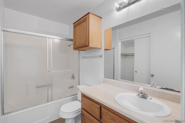 full bathroom with shower / bath combination with glass door, vanity, and toilet