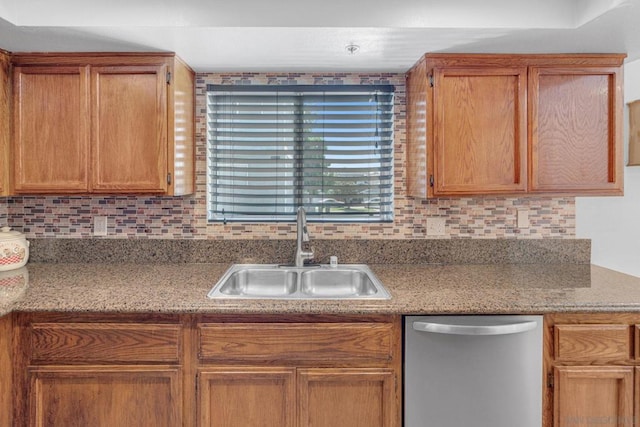 kitchen with dishwasher, backsplash, light stone counters, and sink