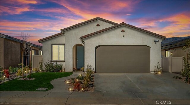 5097 Larkspur Rd, Banning, CA 92220 - mediterranean / spanish house featuring an attached garage, concrete driveway, and stucco siding