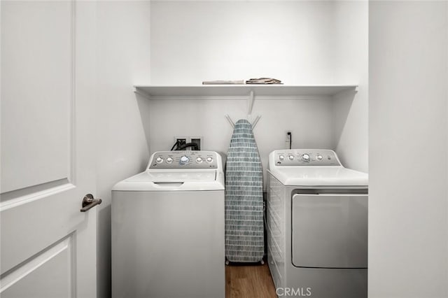 laundry room with dark hardwood / wood-style flooring and washing machine and clothes dryer