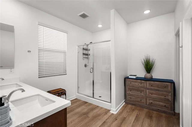 bathroom featuring wood-type flooring, vanity, and an enclosed shower