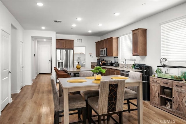 5097 Larkspur Rd, Banning, CA 92220 - kitchen with stainless steel appliances, a center island, a kitchen bar, light wood-style flooring, and recessed lighting