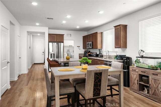 5097 Larkspur Rd, Banning, CA 92220 - kitchen featuring appliances with stainless steel finishes, a center island, a breakfast bar, light wood finished floors, and recessed lighting