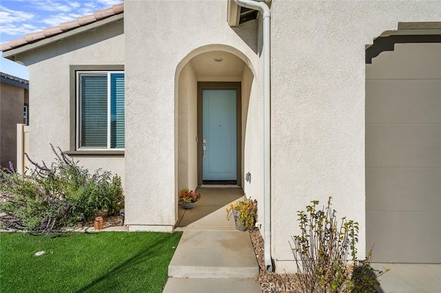 doorway to property with a lawn