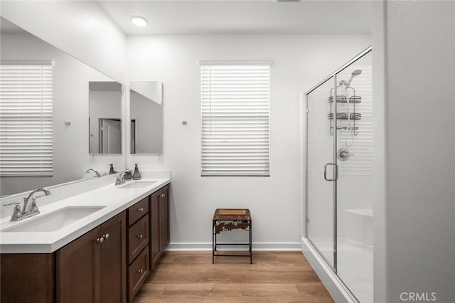 5097 Larkspur Rd, Banning, CA 92220 - bathroom featuring double vanity, wood finished floors, a shower stall, and baseboards