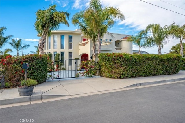 view of front of house with a gate and stucco siding