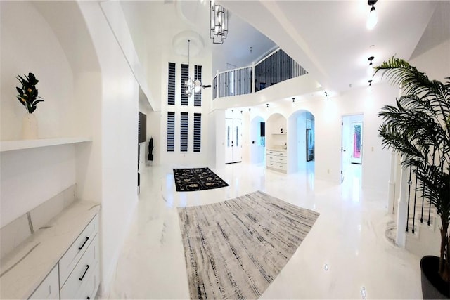 foyer featuring a notable chandelier and a towering ceiling