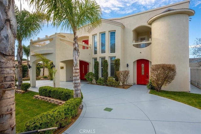 mediterranean / spanish-style house featuring a balcony and stucco siding