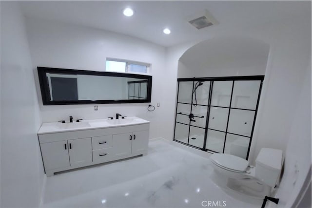 bathroom featuring a stall shower, toilet, marble finish floor, a sink, and recessed lighting