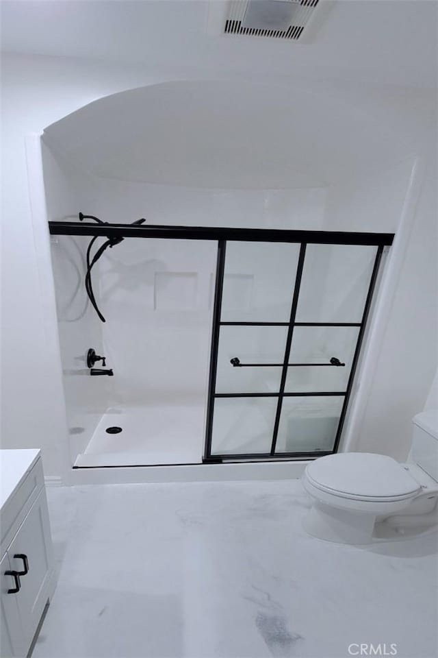 bathroom featuring toilet, walk in shower, and vanity