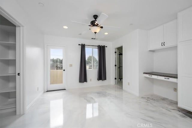 unfurnished dining area featuring a ceiling fan, recessed lighting, built in study area, and baseboards